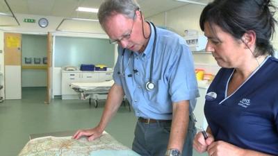 Doctor pointing out rural areas on map