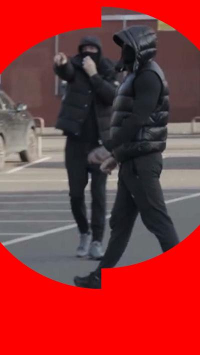 People dressed in black, balaclavas cover their faces