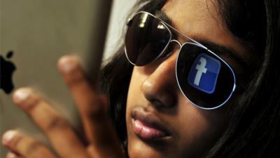 Young Indian woman browses Facebook on her tablet