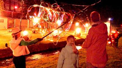 Three people watching a fire display