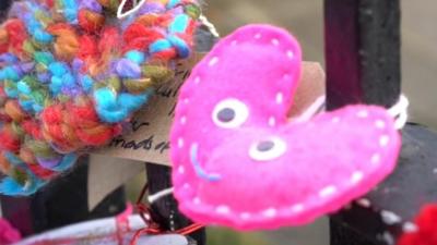 A pink knitted heart with a smiley face