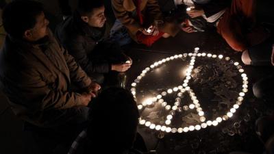 People gather in tribute of the victims of the Paris attacks at the Place de la Republique in Paris, on November 15, 2015