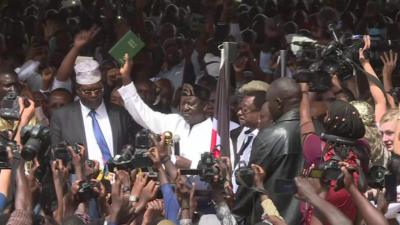 Opposition leader Raila Odinga holds up a copy of the Bible as he announces himself as the President of Kenya