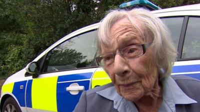 Anne outside a police car