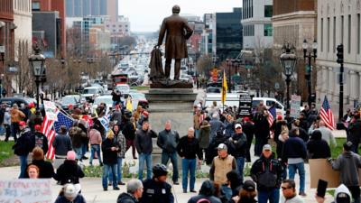 Workers blocked roads demanding the state reopen after the governor extended stay-at-home restrictions.