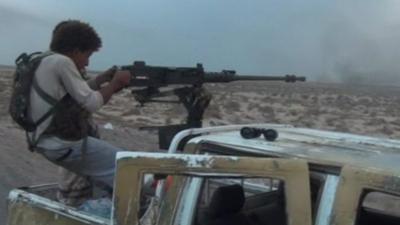 Man firing machine gun from vehicle