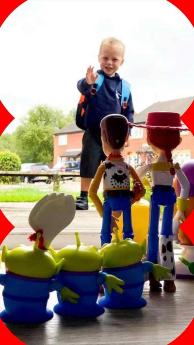 A young boy in a school uniform waves to his toys as he leaves the house