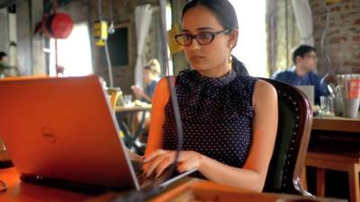 woman working on laptop in a cafe in India