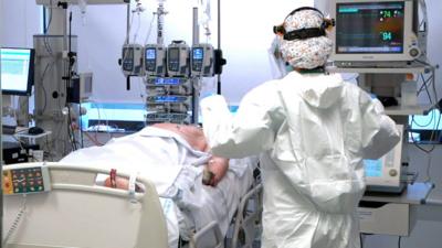 A medic monitors a Covid-19 patient in a Madrid hospital's Covid-19 ward