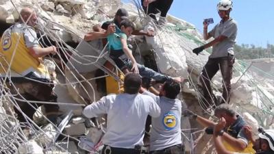 A child is pulled from a destroyed building after an explosion in Idlib, Syria