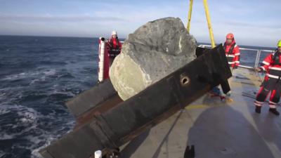 Boulder tipping into the sea