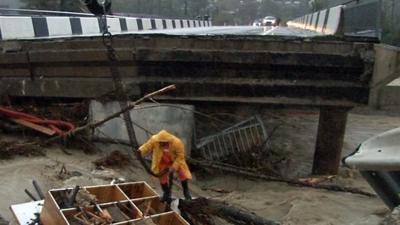 A road bridge destroyed by a river bursting its banks