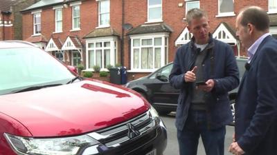 Rory stood by a car