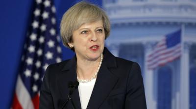 Theresa May with US flag behind her