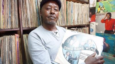 Stallholder holds vinyl record