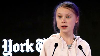 Greta Thunberg speaking at Davos on stage.