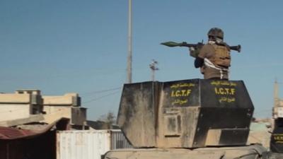 An Iraqi soldier fires a rocket-propelled grenade from an armoured vehicle