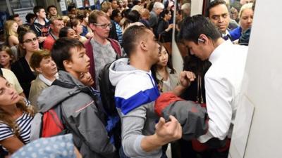 Commuters try to get onto a tube train at Westminster station