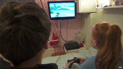 Children playing a computer game in their bedroom