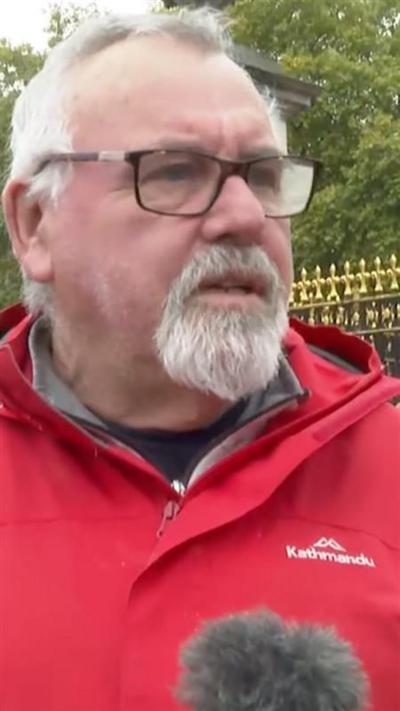 Man wearing glasses and red jacket speaking