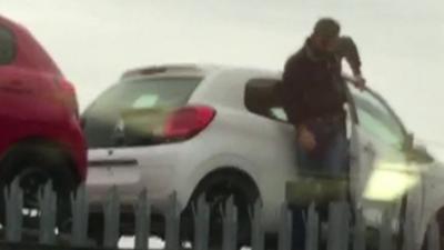 Man getting out of a car on a car transporter