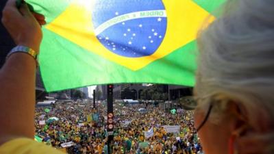 Protester holds up a Brazil flag