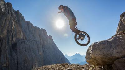 Lutz soaring through the air on his unicycle