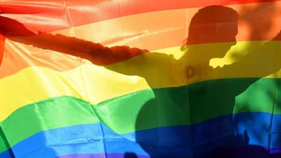 Man holding rainbow flag