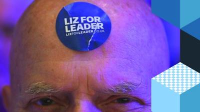 Man with a Liz for Leader sticker on his head