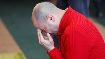 A worshipper weeps as he prays at the reopened Quebec Islamic Cultural Centre