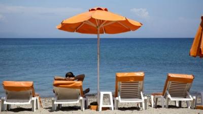 A man relaxes under parasols on the beach