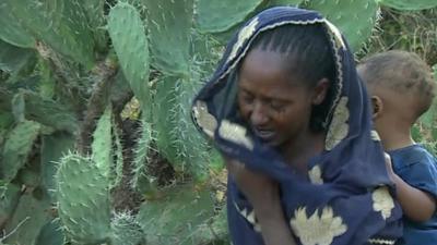 Weeping woman with baby in Ethiopia