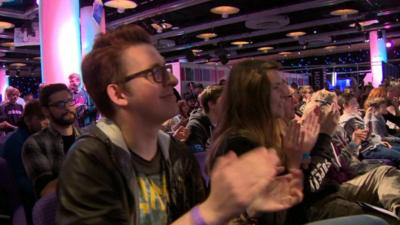 Stuart Main and other young people in audience at a gaming conference.