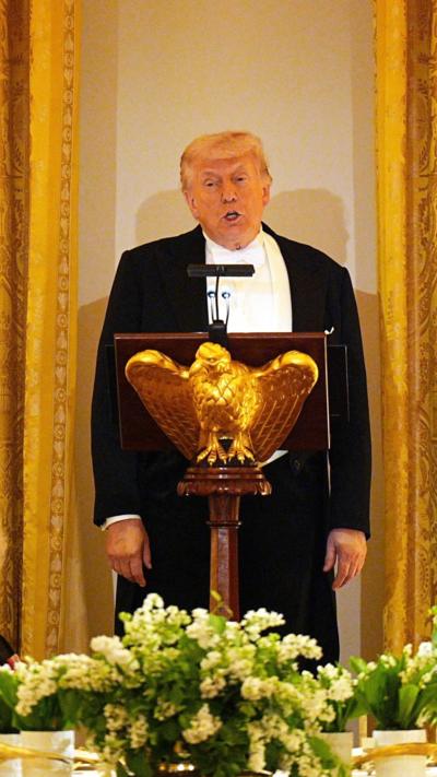 Donald Trump, dressed in a tuxedo with a white bow ties, speaks at a lecturn