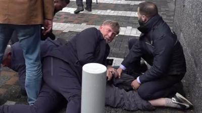 Security pinning down a protester