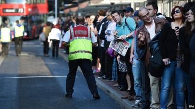 Commuters try to board buses at Victoria Station in London