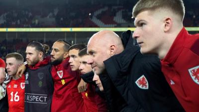 Wales staff and players in a huddle after the Latvia win