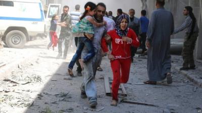 A Syrian family runs for cover following a reported air strike Aleppo