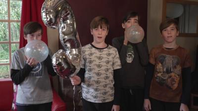 Four brothers with a balloon