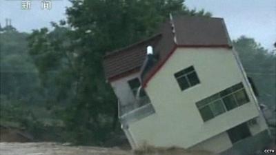 A house in China's Hubei province topples sideways as it collapses into floodwaters