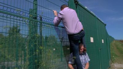 MEP Mike Hookem climbs the fence to prove how easy it is to scale