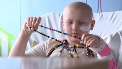 Child patient holding beads