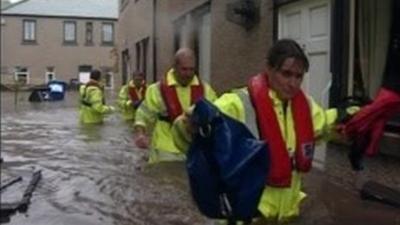 Rescuers wade through waist high water