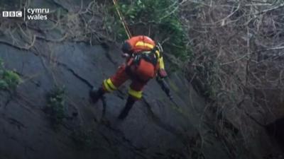 Fireman abseiling down the cliff