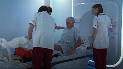 Patient and nurses standing near cancer machine