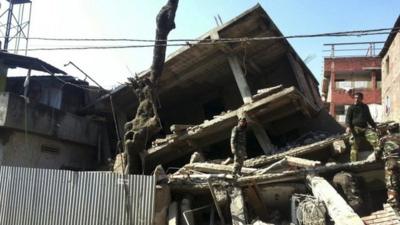 Soldiers inspect a collapsed property in Imphal