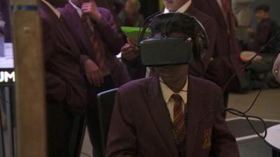 A boy uses a virtual reality headset to explore Chernobyl.