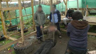 Children playing in the migrant camp known as the Jungle in Calais