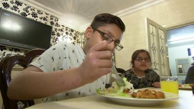 Sahil (l) eating his dinner