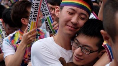 Same-sex activists hug outside the parliament in Taipei
